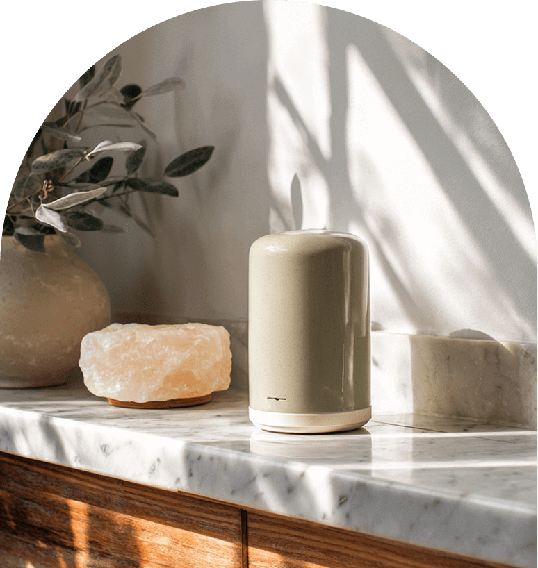 A serene arrangement of a candle, salt rock, and decorative items on a sunlit marble surface.