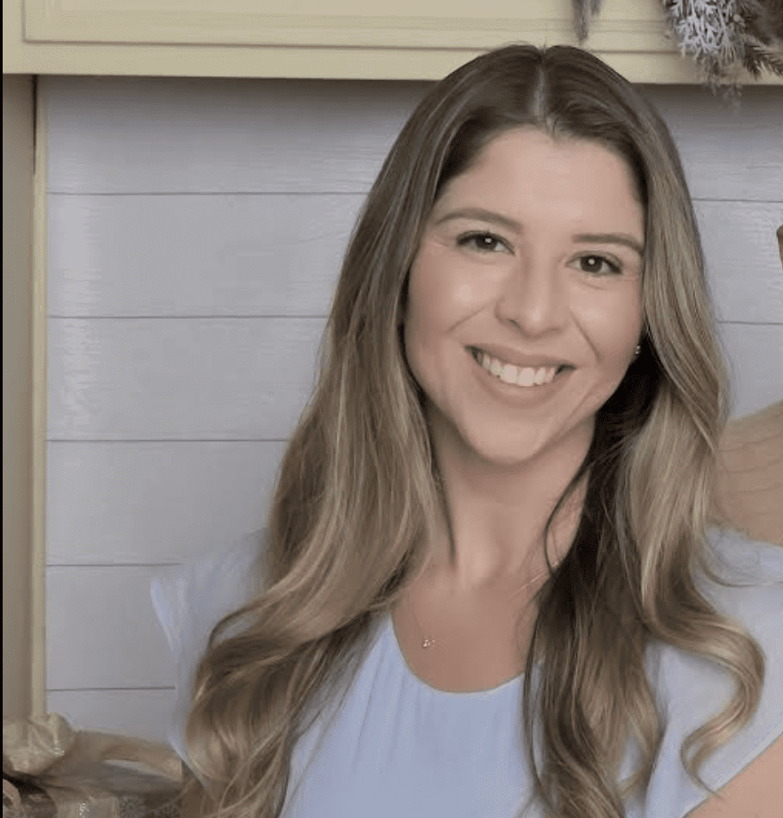 Smiling woman with long hair indoors.
