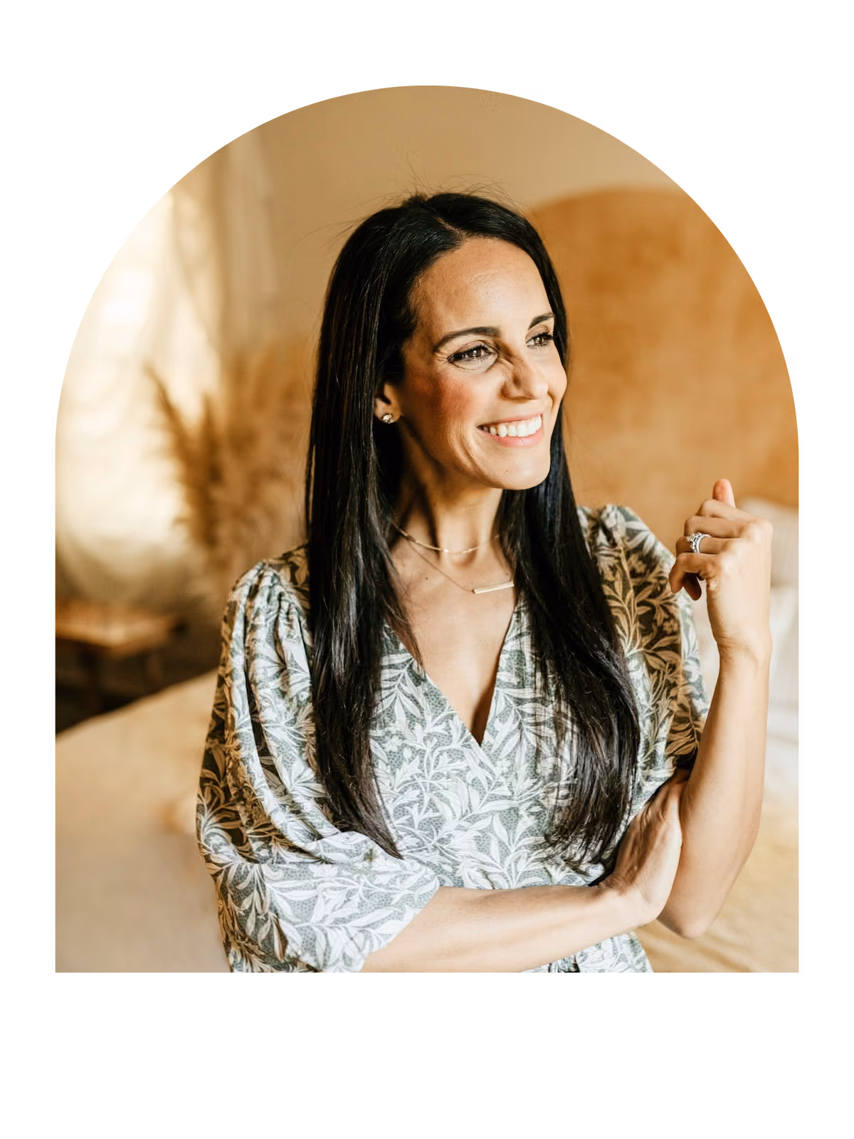 Smiling woman in patterned dress indoors.